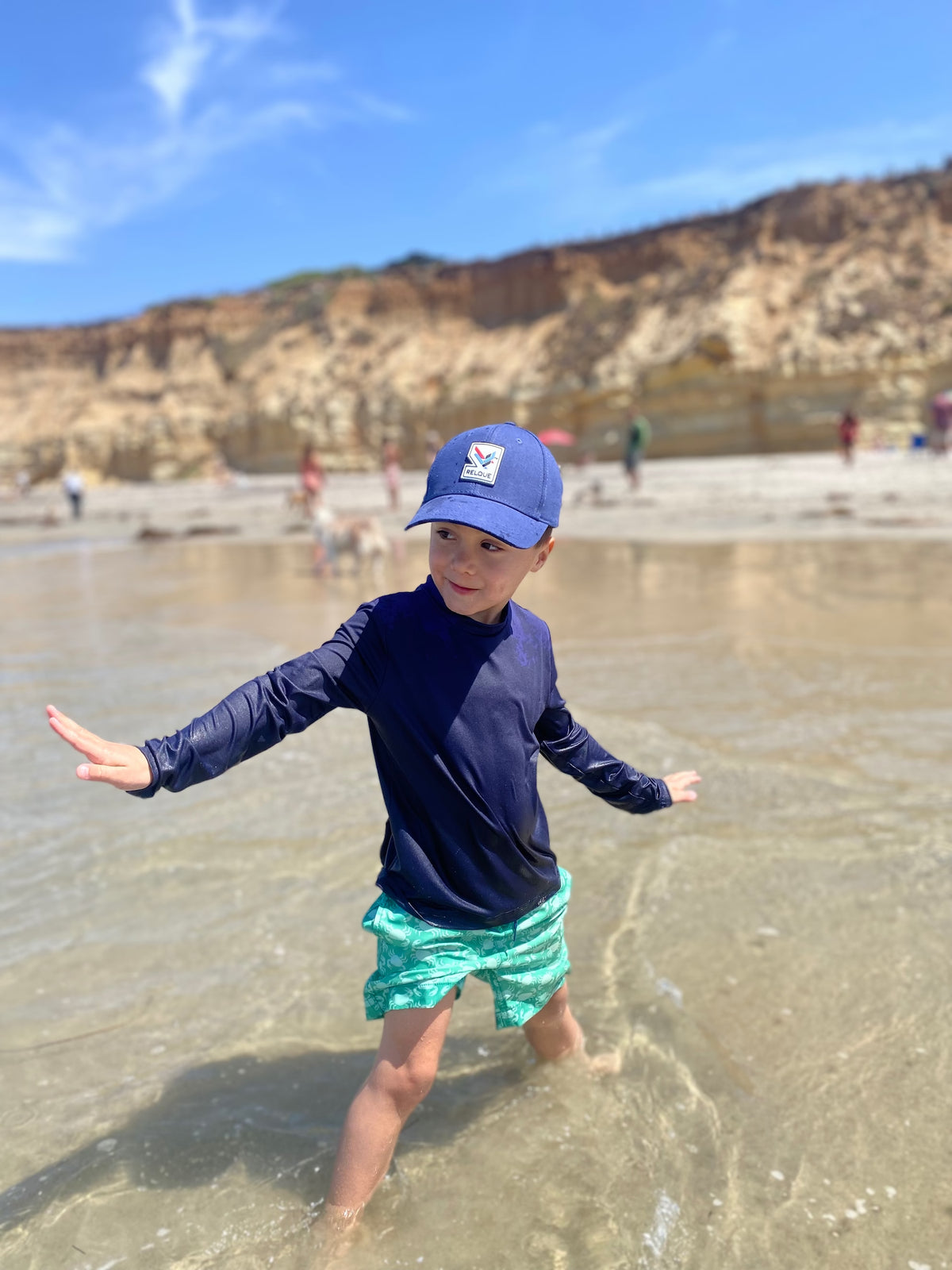 Child wearing the Relque Andes Mini Cap at the beach